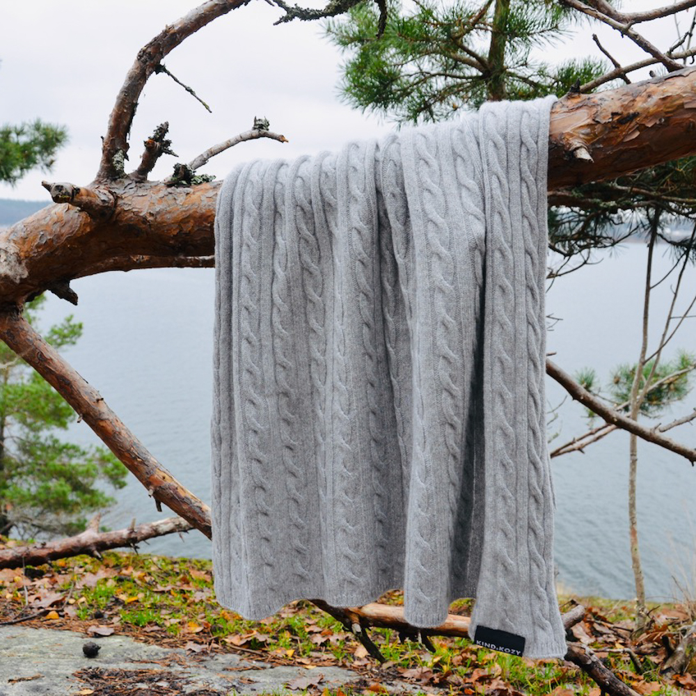 KIND&KOZY grey blanket draped over tree branch